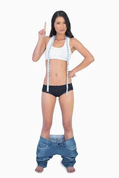 Mulher inteligente vestindo jeans caindo porque ela perdeu peso — Fotografia de Stock