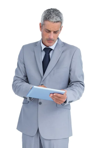 Frowning businessman using tablet pc Stock Photo