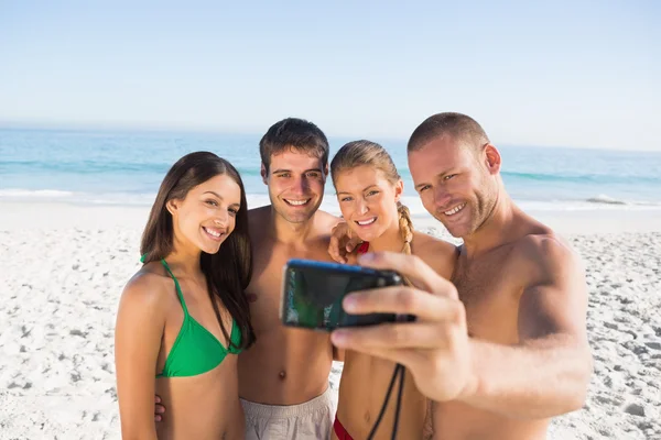 Smiling friends taking pictures of themselves Stock Image