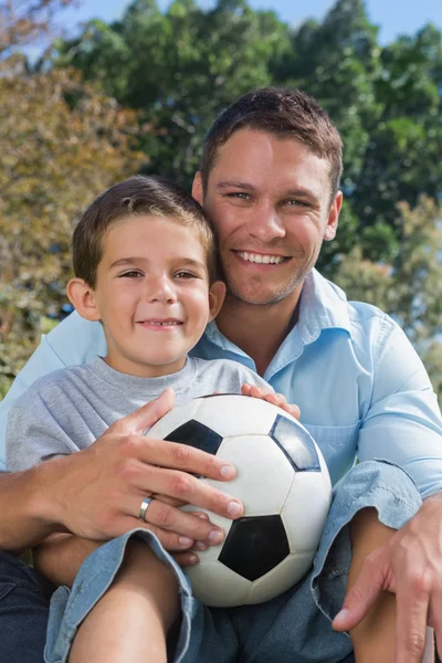 Glad pappa och son med fotboll Stockfoto
