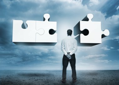 Businessman standing looking at jigsaw puzzle