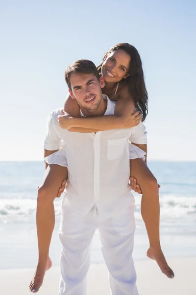 Lächelnder Mann schenkt glücklicher Freundin ein Huckepack — Stockfoto