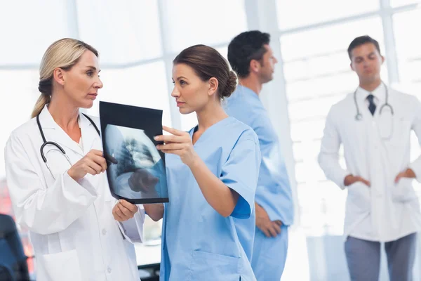 Chirurg i lekarz analizy rentgenowskiej razem — Zdjęcie stockowe