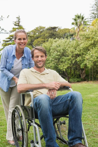 Happy man in wheelchair with partner — Stock Photo, Image