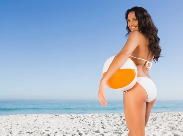 Sorrindo sexy morena em biquíni branco com bola de praia — Fotografia de Stock