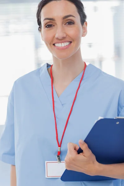 Lächelnde Krankenschwester mit Akten und Blick in die Kamera — Stockfoto