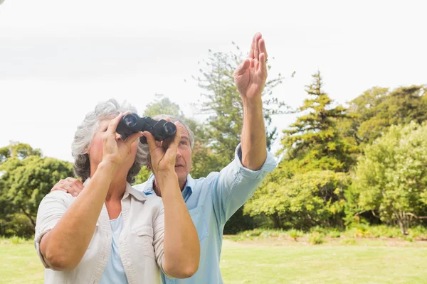 Man pointing to something for his wife holding binoculars — Stock Photo, Image