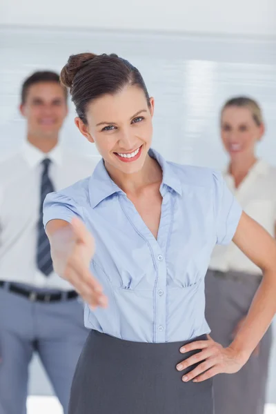 Mujer de negocios sonriente extendiendo su mano a la cámara —  Fotos de Stock