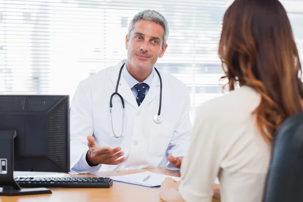 Leende läkare pratar med sin patient — Stockfoto