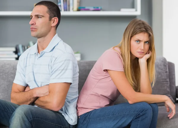 Couple sitting back to back after a fight on the couch with woma — Stock Photo, Image