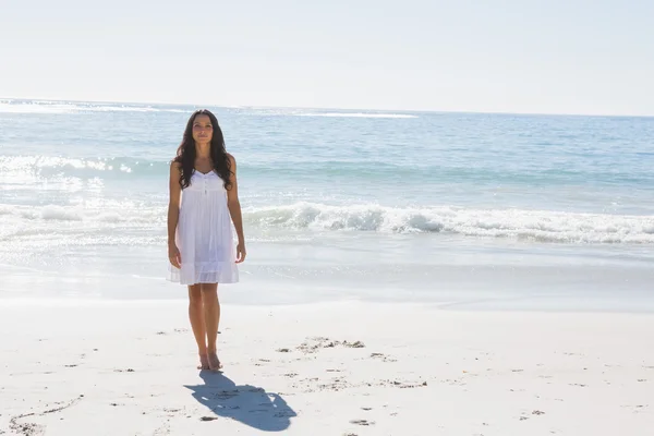 Linda morena em vestido de sol branco andando do oceano — Fotografia de Stock