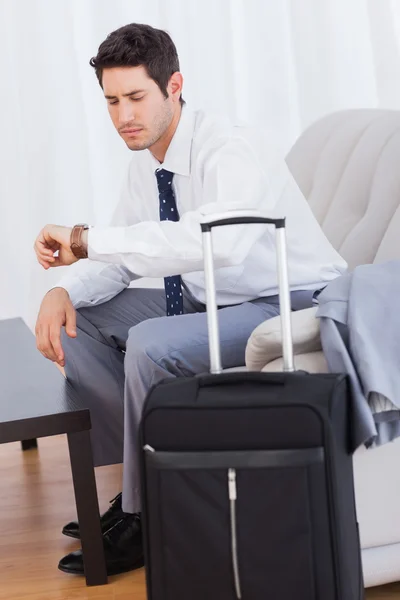 Geschäftsmann mit Gepäck, das auf dem Sofa auf den Flug wartet — Stockfoto