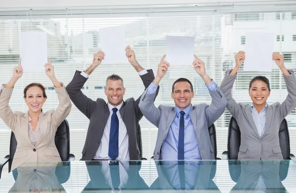 Sonriente panel de entrevistas sosteniendo hojas en blanco por encima de su cabeza hola — Foto de Stock