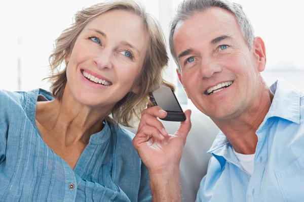 Lyckliga paret lyssnar på mobiltelefon tillsammans — Stockfoto