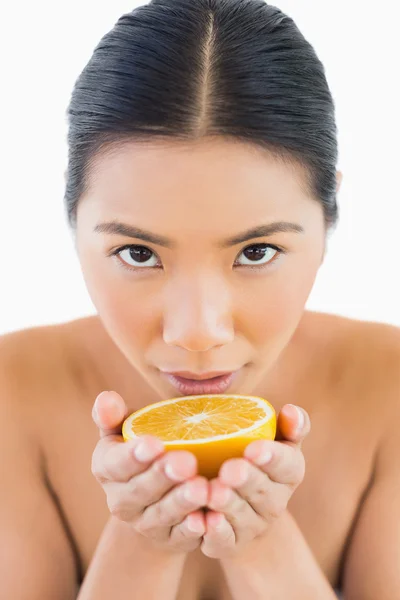 Zufriedene hübsche Frau mit Orange in den Händen — Stockfoto