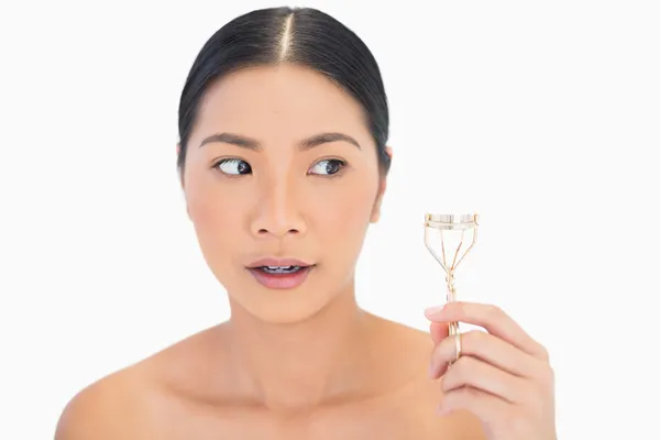 Worried natural model with eyelash curler — Stock Photo, Image