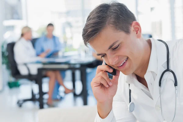 Un médico joven recibiendo una llamada telefónica — Foto de Stock