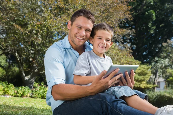 Feliz pai e filho com um tablet pc — Fotografia de Stock