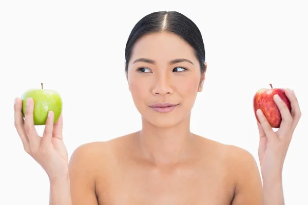 Modèle aux cheveux noirs tenant des pommes dans les deux mains en regardant le g — Photo