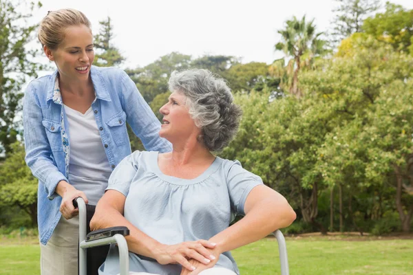 Uśmiechający się starsza kobieta na wózku inwalidzkim, rozmawia z córką — Zdjęcie stockowe