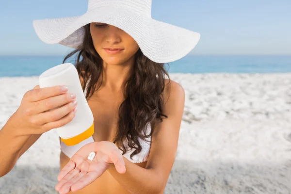 Sexy young brunette taking care of her body putting on sun cream — Stock Photo, Image
