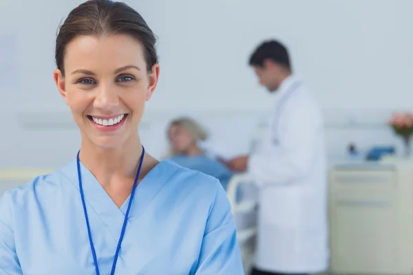 Cirurgião alegre posando com médico assistente paciente no backgro — Fotografia de Stock