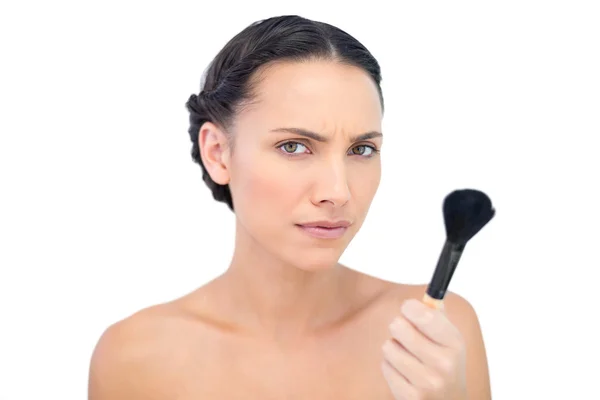 Serious natural model holding a powder brush — Stock Photo, Image