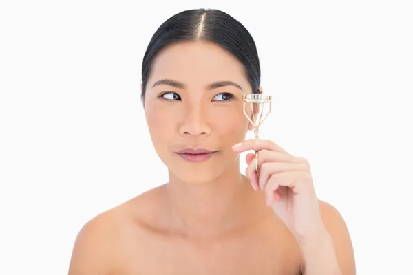 Natural dark haired woman with eyelash curler — Stock Photo, Image