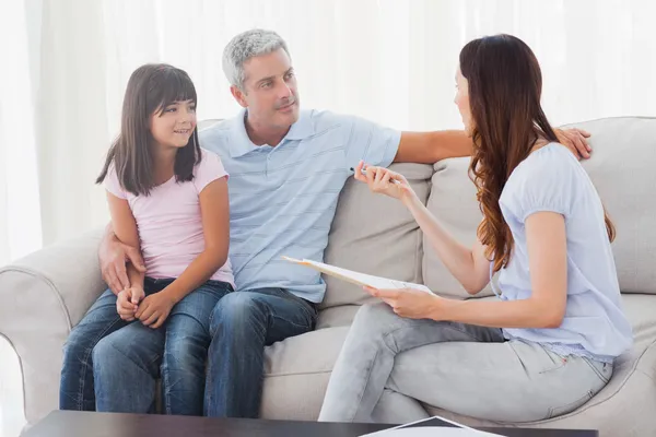 Parents avec leur fille assise sur le canapé — Photo