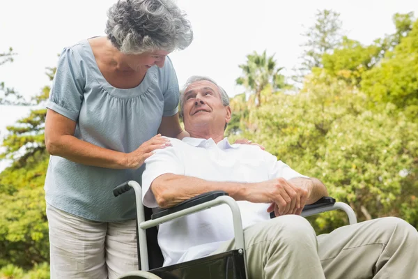 Glad mogen man i rullstol talar med partner — Stockfoto