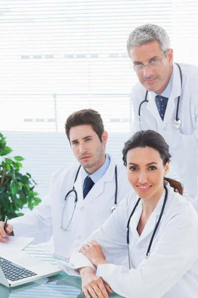 Team of doctors working together looking at camera — Stock Photo, Image