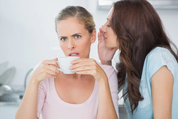 Morena diciendo secreto a su amigo mientras bebe café —  Fotos de Stock