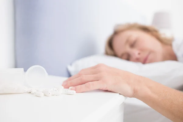 Blondine liegt nach Tablettenüberdosis regungslos im Bett — Stockfoto