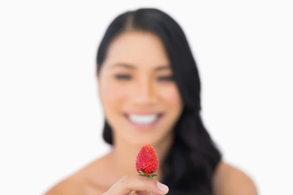 Attraente modello dai capelli castani che tiene la fragola — Foto Stock