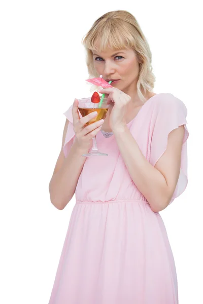 Hübsche blonde Frau trinkt Cocktail und schaut in die Kamera — Stockfoto