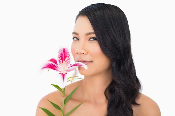 Peaceful natural brown haired model smelling lily — Stock Photo, Image