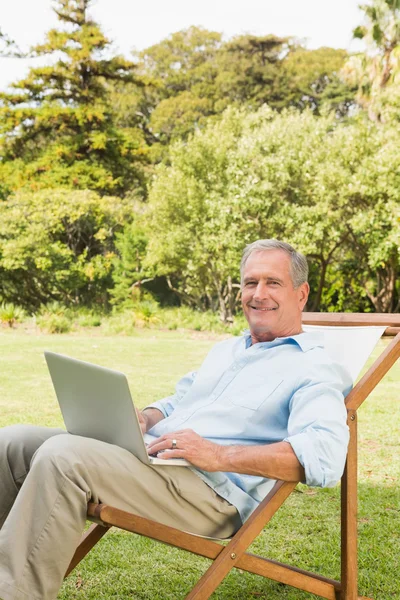 Χαμογελώντας ώριμος άνδρας, χρησιμοποιώντας φορητό υπολογιστή — Φωτογραφία Αρχείου