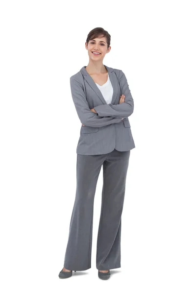 Cheerful businesswoman with arms crossed smiling at camera — Stock Photo, Image