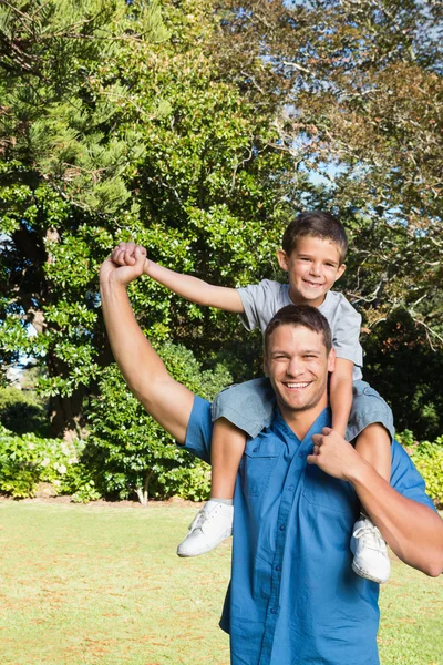 Son sitting on his fathers shoulders — Stock Photo, Image