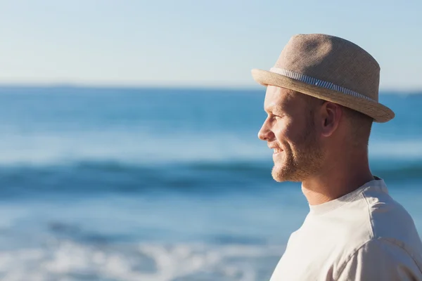 Bell'uomo con il cappello di paglia che guarda il mare — Foto Stock