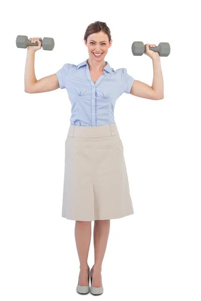 Strong businesswoman posing with dumbbells — Stock Photo, Image