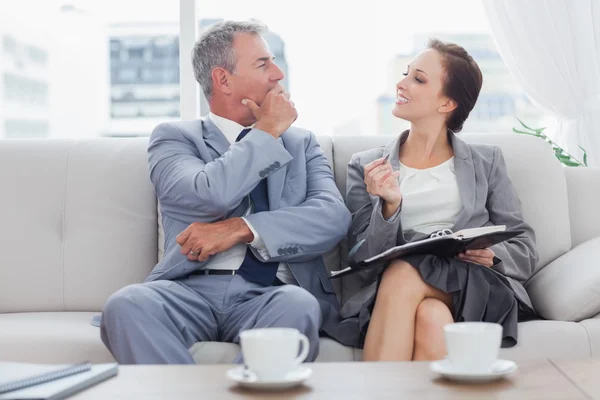 Kollegen sitzen zusammen auf dem Sofa und trinken Kaffee — Stockfoto