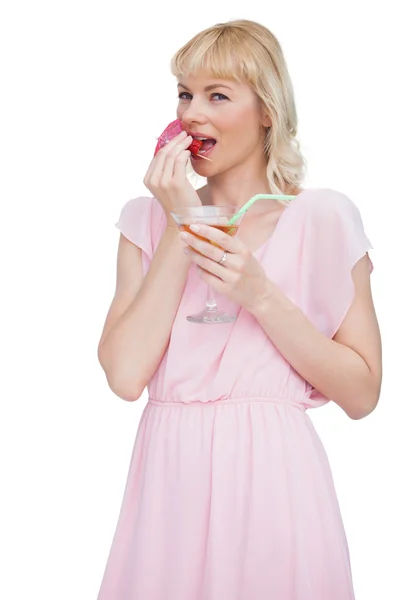 Красивая блондинка с коктейлем ест фрукты — стоковое фото