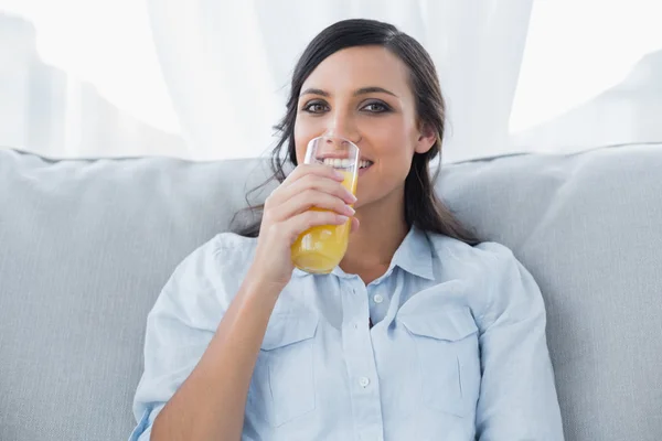 Uśmiechnięta brunetka picia soku pomarańczowego — Zdjęcie stockowe