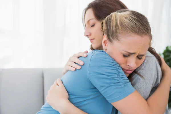 Woman taking her friend in her arms — Stockfoto