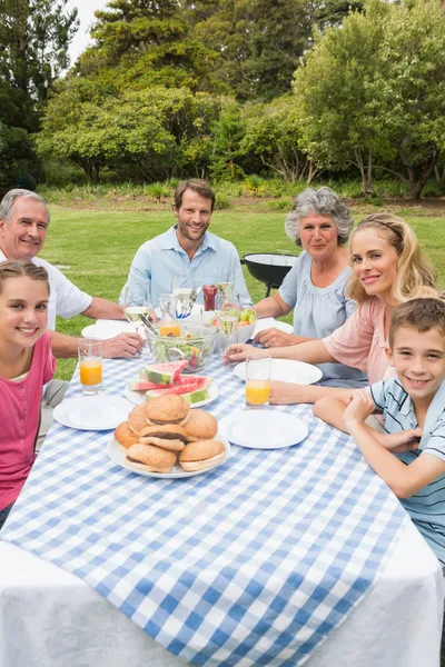 Alegre família estendida jantando ao ar livre na mesa de piquenique — Fotografia de Stock