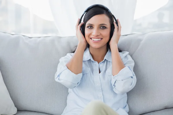 Morena sorridente ouvindo música — Fotografia de Stock