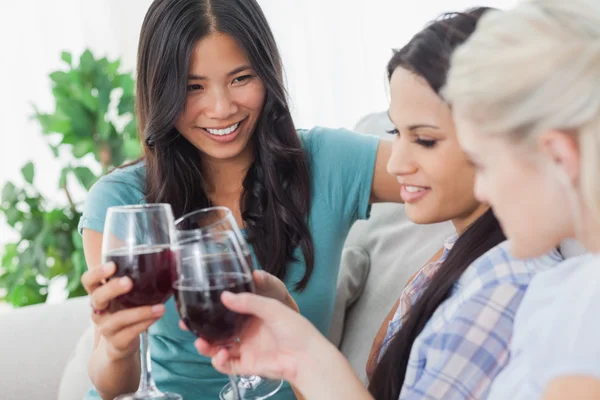 Amigos alegres tendo vinho tinto juntos — Fotografia de Stock