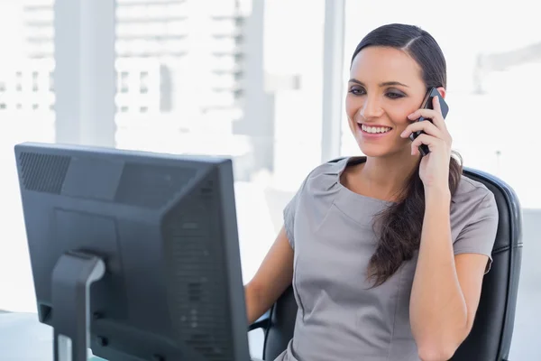 Sorrindo mulher de negócios de cabelos escuros ter uma conversa telefônica — Fotografia de Stock