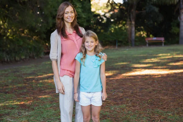 Mother smiling at camera with her daughter — Stock Photo, Image